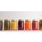 multiple glass jars of vegetables pickles and jams.