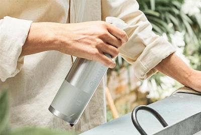Image of person spraying a kitchen surface with reusable spray bottle