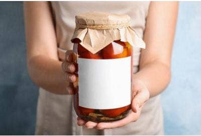 A woman holding a homemade canning offering