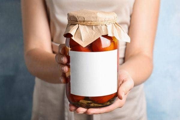 A woman holding a homemade canning offering